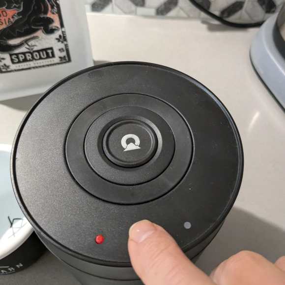 pressing the vacuum button on an outpeak coffee canister